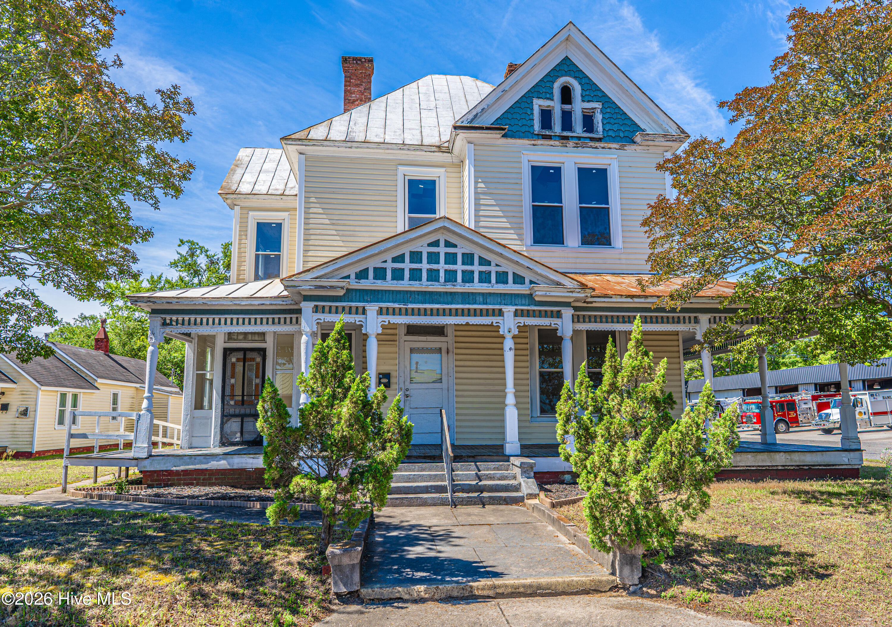 115 Main Street presents a rare opportunity to own a versatile commercial property in the heart of downtown Hamlet. Situated on a prominent corner lot along Main Street, this unique offering includes two separate buildings with income-producing potential and exceptional historic charm.The primary building is rich with early 1900s Victorian character and architectural detail. From the decorative trim and solid wood doors to the inviting wrap-around covered front porch, this property offers a distinctive professional setting full of timeless appeal. Inside, the main level features numerous office spaces with optional separate entrances, allowing flexibility for your business, private suites, or professional services. Additional amenities include a kitchen, restroom, and several fireplaces that enhance the historic atmosphere throughout the space.Upstairs is currently utilized for storage, but with a little TLC, the second floor could easily be transformed into multiple additional offices, creative workspaces, or income-producing suites.Also included is a detached office building currently leased as a hair salon, providing immediate monthly rental income. This separate structure includes a welcoming lobby, salon area, kitchen, and restroom, making it ideal for continued salon use or other small business opportunities.Conveniently located between the post office and the police and fire station, this high-visibility property offers excellent accessibility to the Hamlet Train Depot, Hamlet City Hall, local industries, and ongoing area development. Whether you are seeking a headquarters for your business, an investment property, 115 Main Street delivers location, character, and potential all in one package