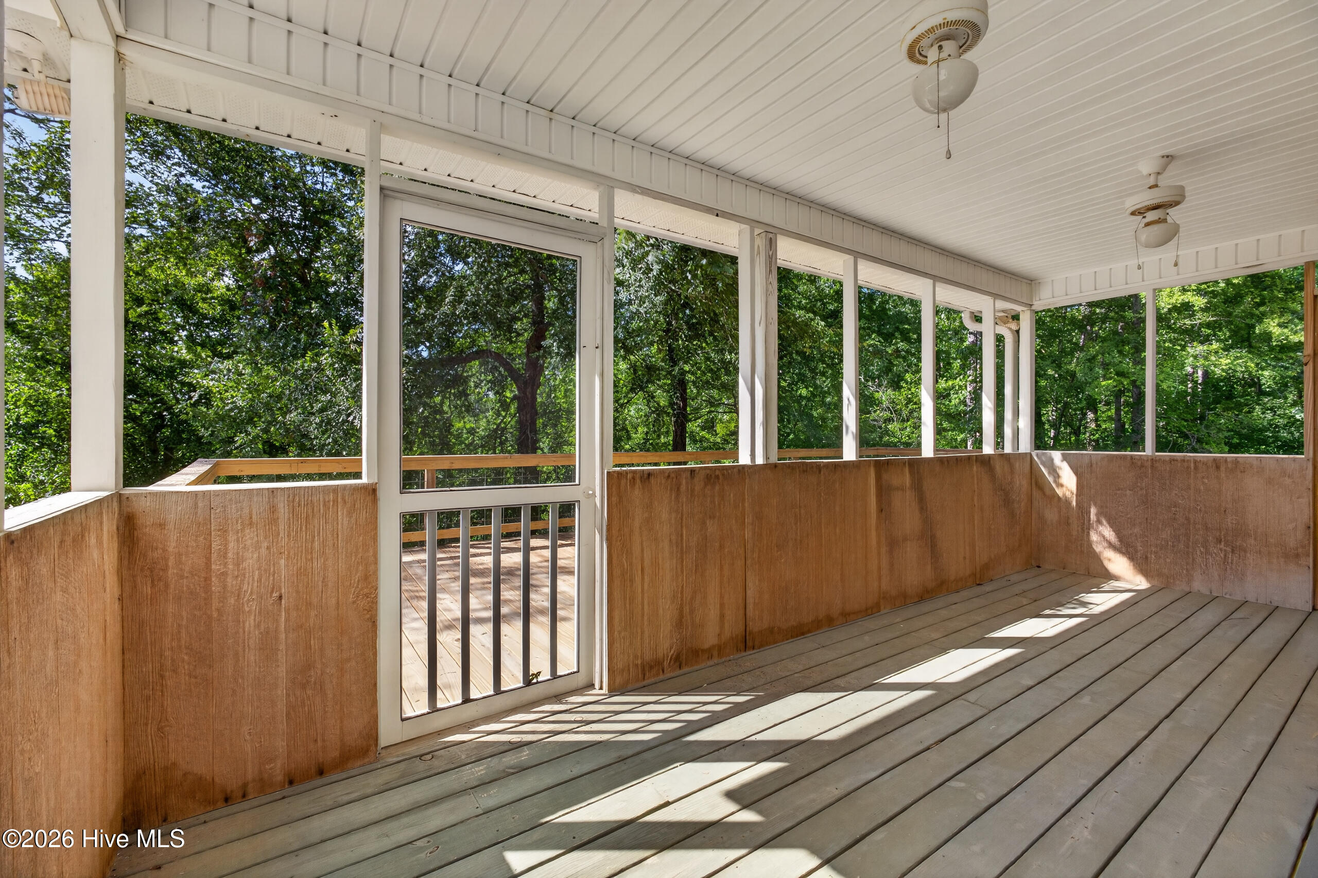 Large, screened porch and spacious deck overlook private backyard