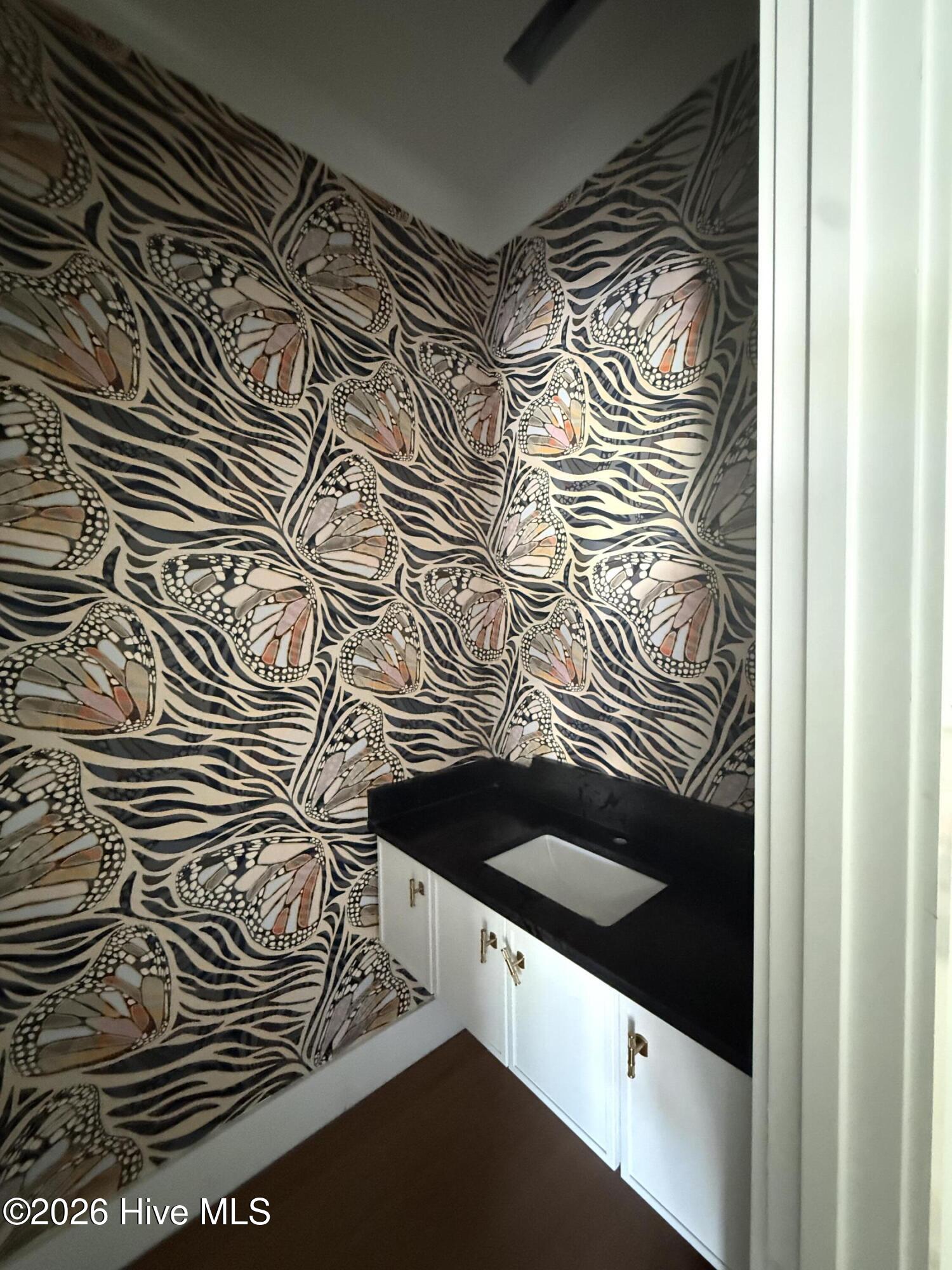 down stairs powder room , floating sink and beautiful wallpaper