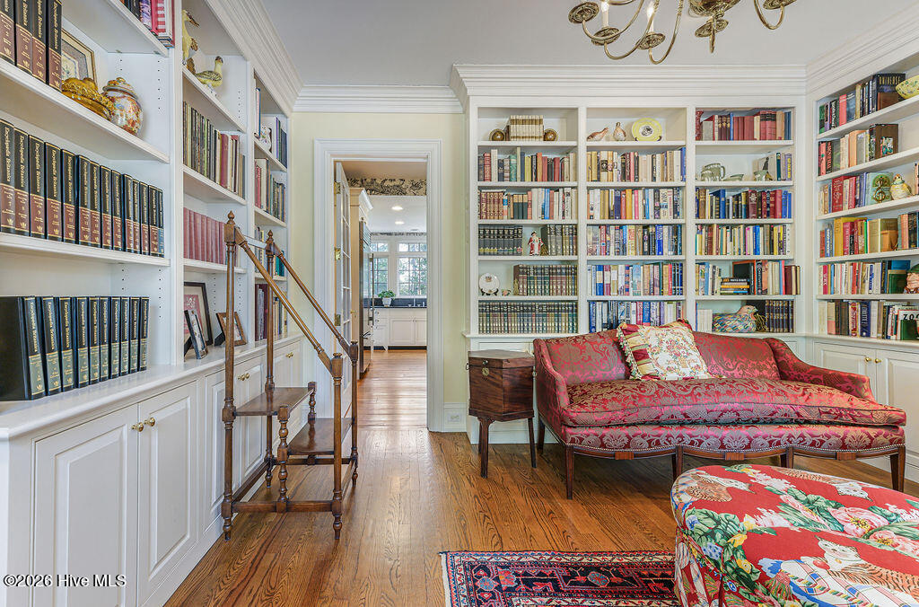 Lined with floor-to-ceiling shelving and cabinetry, open to main kitchen area and open to hallway to garage and rear kitchen with stairway to second floor and basement access