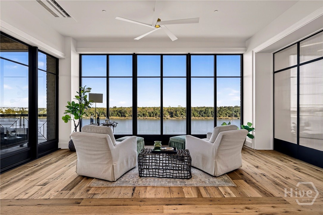 Scenic sunroom with floor-to-ceiling windows. This thoughtfully positioned living space maximizes panoramic views with full-height glass and uninterrupted sightlines. Wide-plank flooring and clean ceiling lines enhance the sense of volume and serenity. A refined retreat designed to showcase natural beauty and architectural clarity.