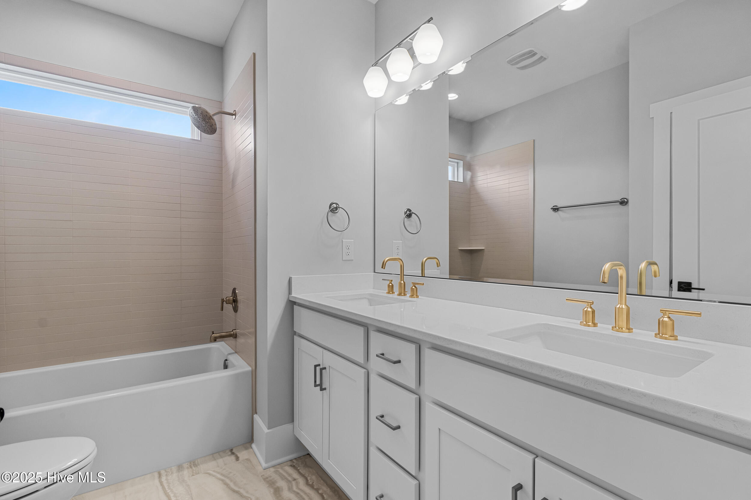 Down stairs bathroom with double sink and bathtub