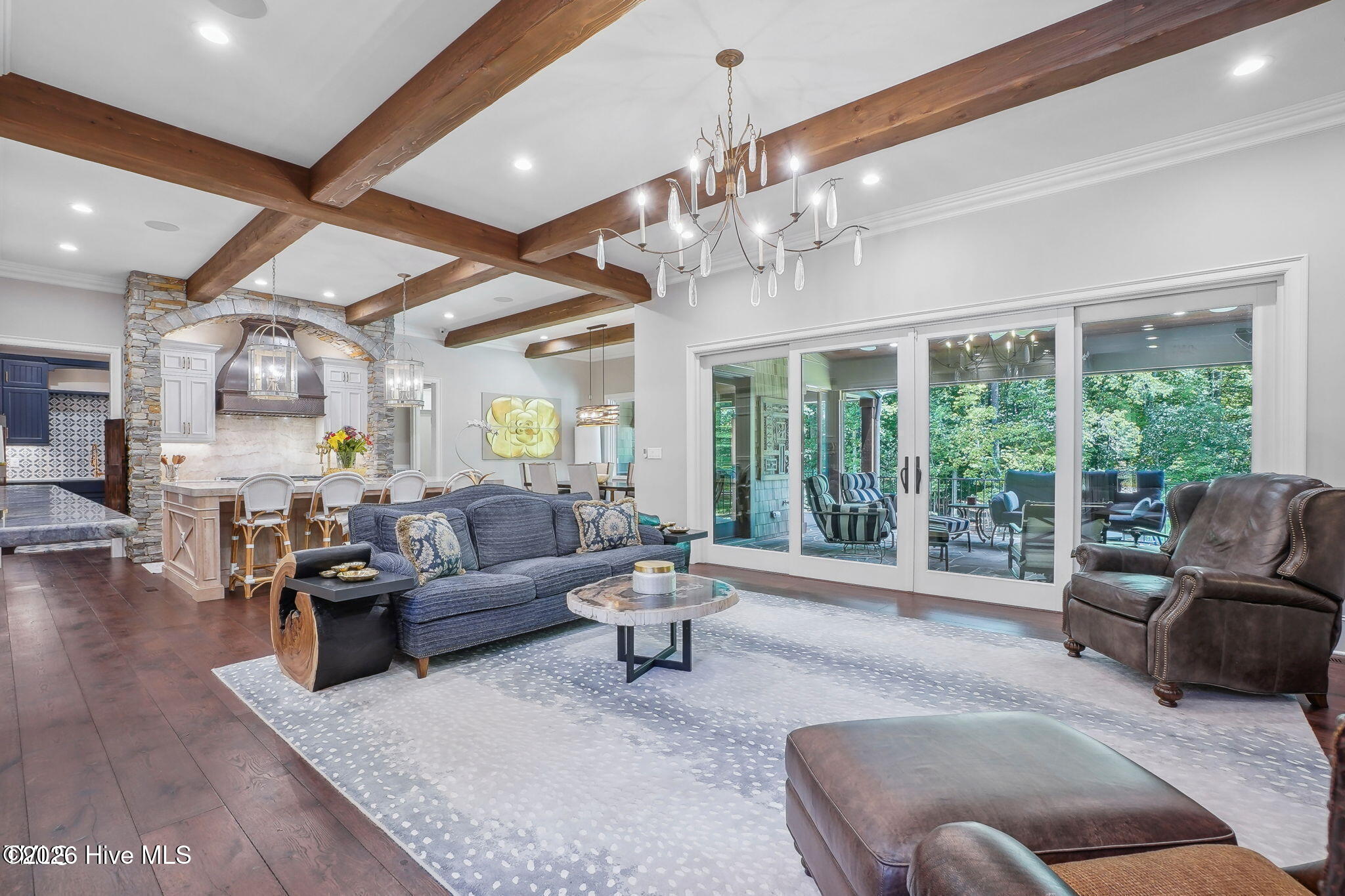 Family room overlooking covered patio. 10 in wide plank engineered flooring character grade