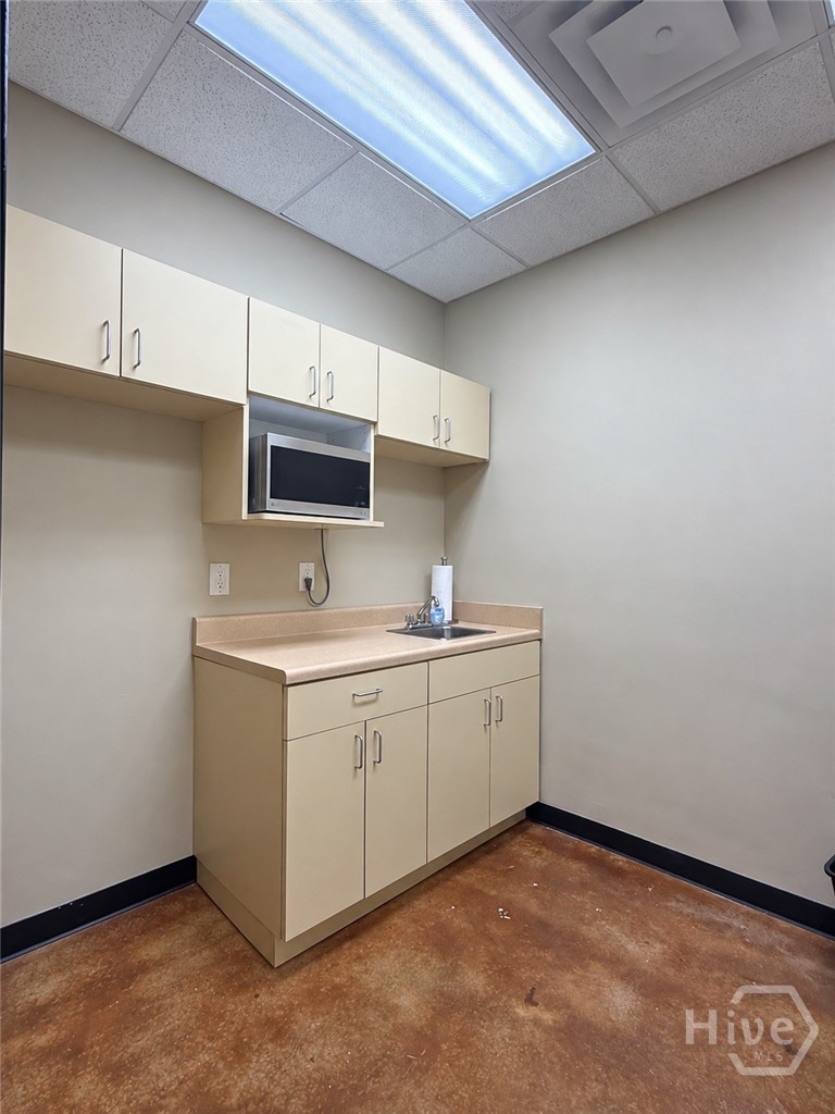 Break room with cabinets, sink and microwave space