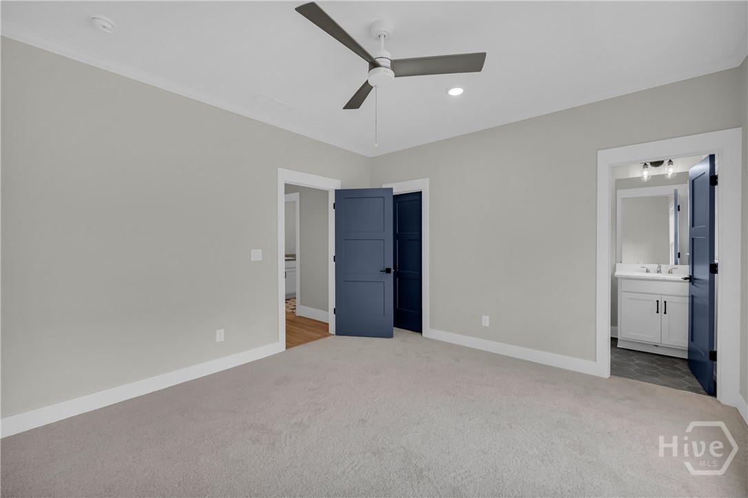 Spacious En Suite Bedroom featuring light gray walls, white trim, and light gray carpeting