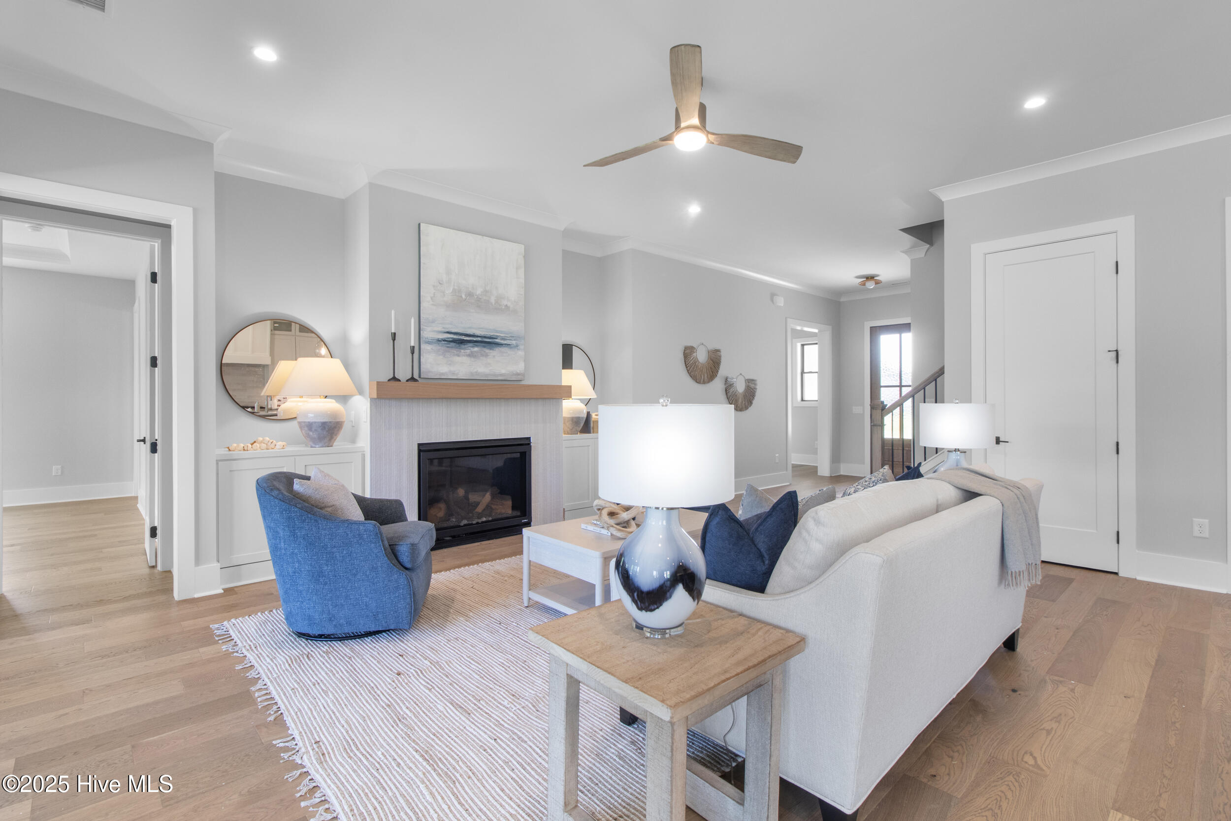 Living room with built ins beside natural gas fireplace