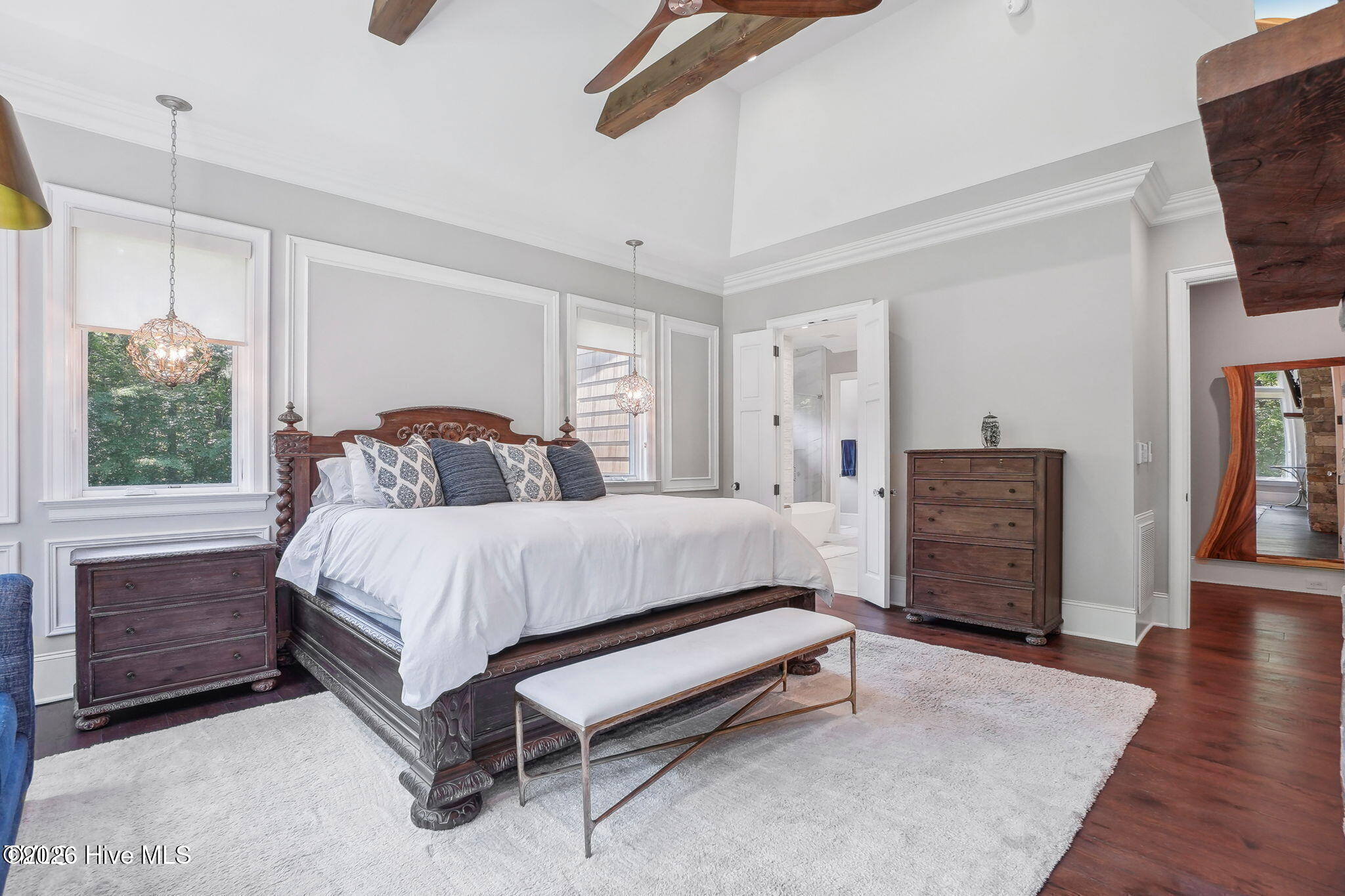 Master bedroom with huge picture windows vaulted ceiling with oversized rustic beams and contemporar