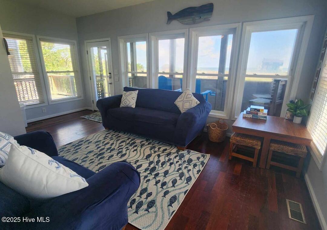 Lower level living room with access to deck and screened in porch and 2 primary bedrooms