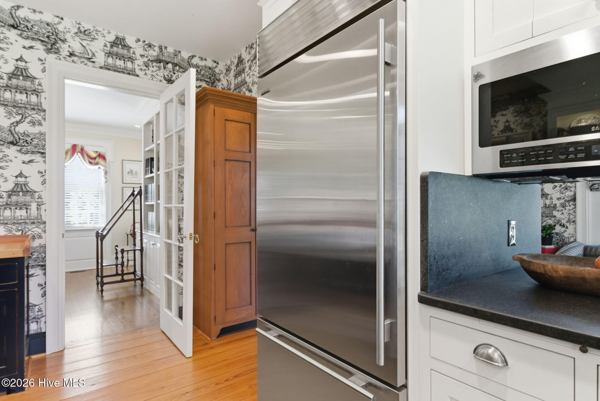 Sub-Zero Full size refrigerator built in cabinetry flows between kitchen and breakfast room.