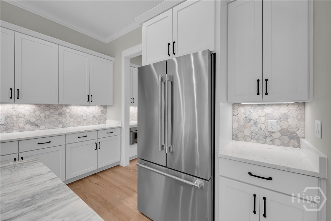 Stunning chef’s kitchen featuring marble and quartz countertops, a complete Thermador stainless steel appliance package, 5-burner natural gas cooktop, dedicated coffee station, and an impressive butler’s pantry for added storage and entertaining convenience