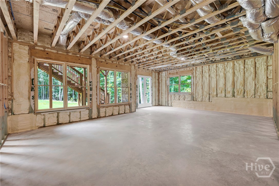 Unfinished basement space featuring exposed wood framing, concrete flooring, and recessed ceiling lighting