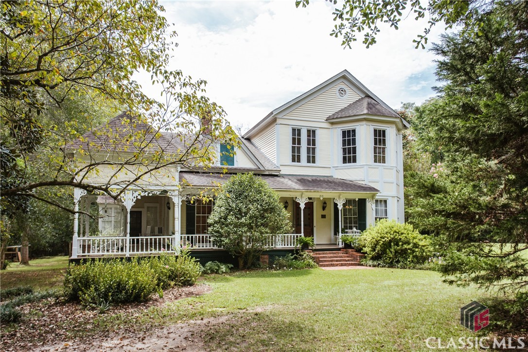 Welcome to "The Pines," a beautiful Queen Anne on The National Register of Historic Places following a decades-in-the-making restoration that returned thehome to its original splendor. Architecturally significant features are located inside and out - they include but are not limited to heart of pine flooring, originalbaseboards, trim, and beadboard walls. Even the hardware on multiple sets of pocket doors and the built-in China cabinet have been preserved. Originalgasolier chandeliers have been preserved and converted for electric use. Located in the heart of Jeffersonville, Georgia, this meticulously restored homecaptures the essence of a bygone era. Sited on 3.42 acres with mature landscaping, this property offers a perfect blend of history, elegance, and modernamenities, all within a convenient 20-minute drive to Macon and 15 minutes to Warner Robins. The home features four bedrooms, two full bathrooms, a halfbathroom, and over 4,000 square feet, providing ample space for the new owner - and perhaps an abundant collection of antiques. The main floor boasts aceiling height of 12 feet, creating an airy and inviting atmosphere, while the upstairs maintains a lofty 10-foot height. Enormous, double-hung windows thatbegin at the floor and almost reach the ceiling have been restored and still have original wavy glass. A formal dining room with original built-in China cabinetand bay window is located just off the spacious Parlor. Both the Parlor and Dining Room feature decorative fireplaces, the Parlor mantel crafted frommarbleized slate with tile inlay bearing the image of a child. The Owner's Suite has several layout options. With a secondary living room at the front of thehome, one could utilize the front room as sleeping quarters and the attached room as a seating or dressing room. The attached bathroom features a vanity,pedestal sink, and tub/shower combo. Additional bedrooms and bathrooms on the main level have access to a sun porch that overlooks the pool and yard.Updated kitchen has stainless steel appliances, solid wood cabinetry, Quartz countertops, and a walk-in pantry. Your outdoor oasis awaits whetherswimming in the pool or lounging on the newly refurbished, 900 square foot rear deck. Mature magnolias, pecan trees, azaleas, crepe myrtles, and otherstunning landscaping elements are interspersed throughout the property. Step back in time and become the next steward of this impeccably restored QueenAnne gem. "The Pines" is more than a home; it's a living piece of history waiting to welcome its next fortunate owner. Don't miss your chance to experiencethe splendor of this extraordinary property.