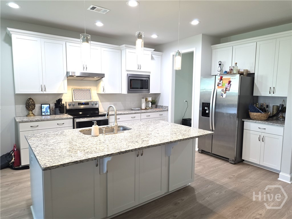 Large kitchen with bar seating, cabinets with drawers, stainless appliances and a huge pantry with space for a nice buffet area as you move to dining area.