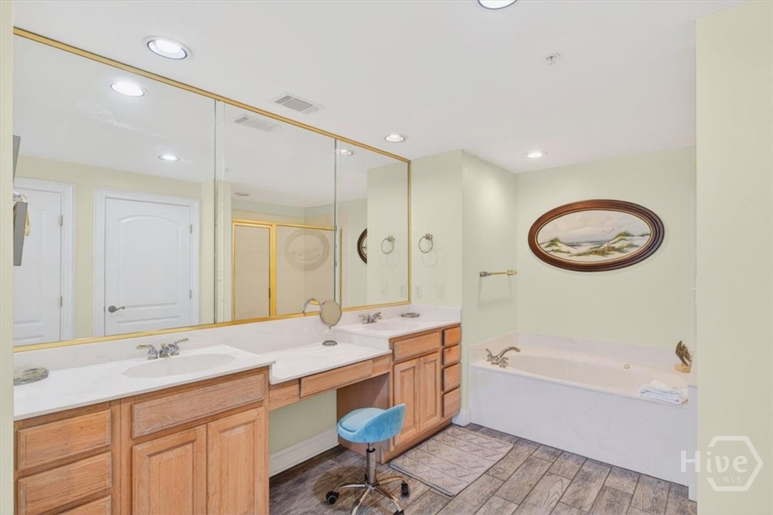 Huge primary en-suite offers ample closet space, a soaking tub, double vanities, and separate shower