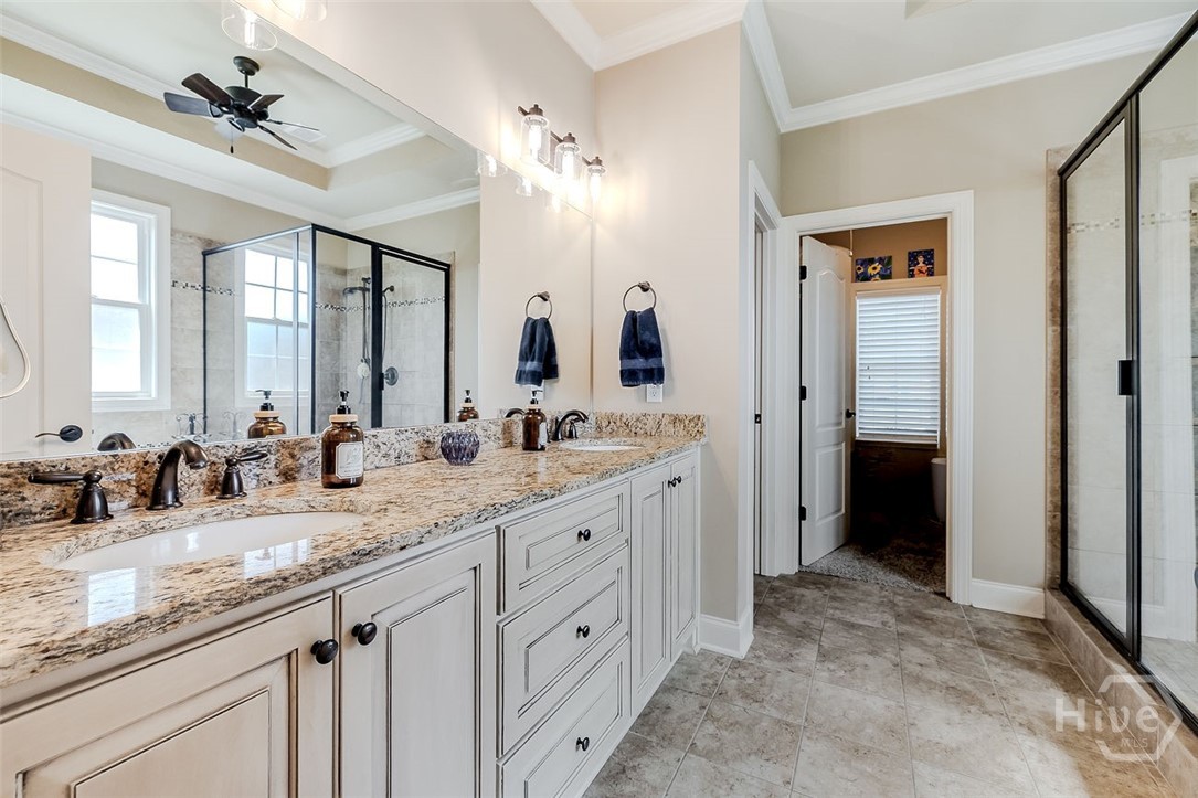 Primary bathroom with double vanity separate shower and tub, large walk in closet with attic access