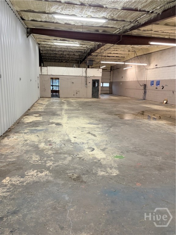 Side of building with office space and two garage bays. One garage bay at back for loading and unloading purposes.