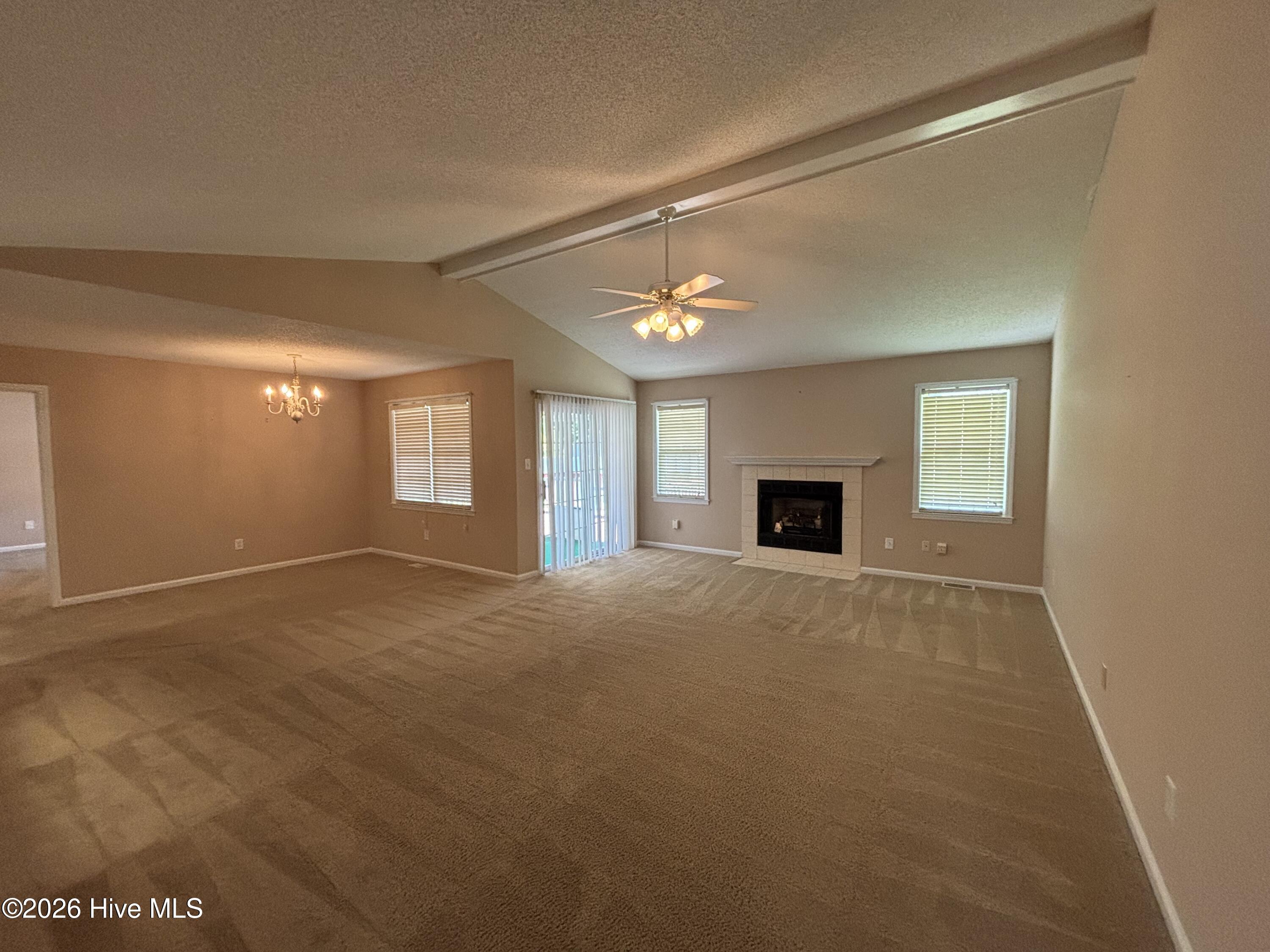 Great room has gas log fireplace and opened to welcoming screened porch