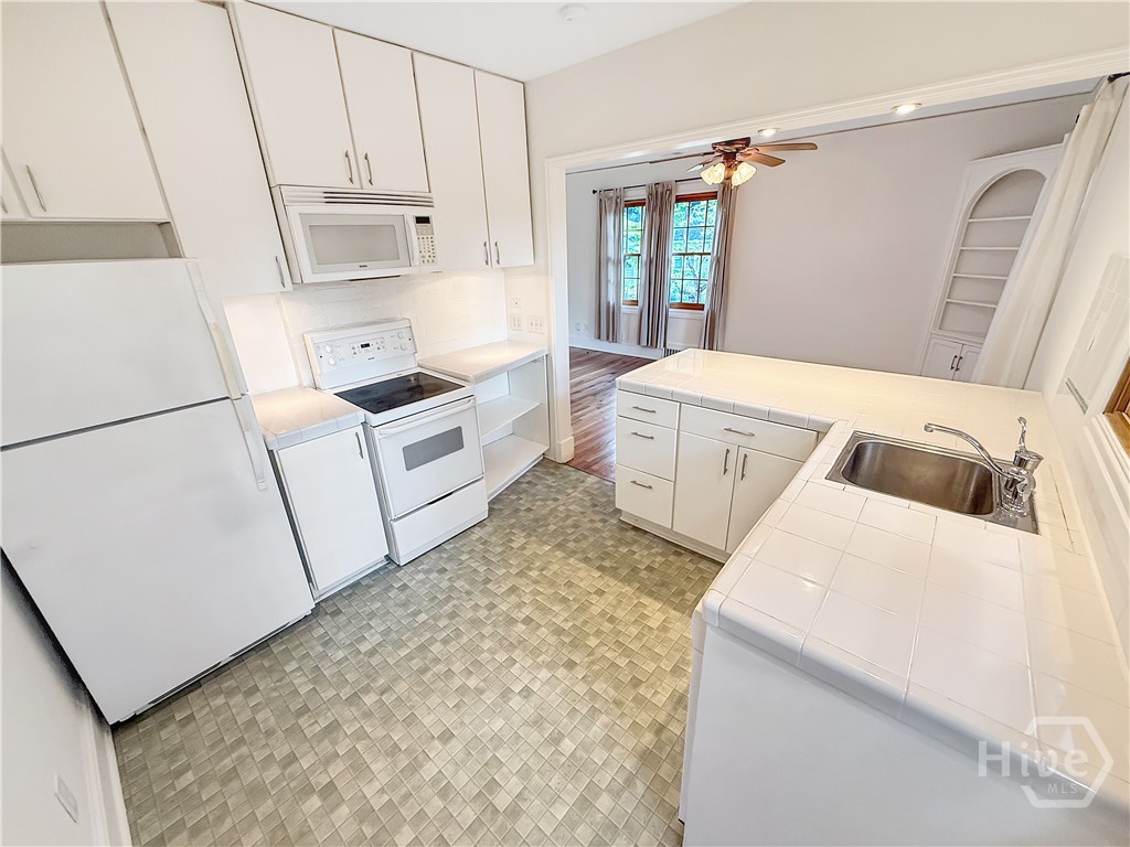 Kitchen w/ Tile Counter Tops and Backsplash