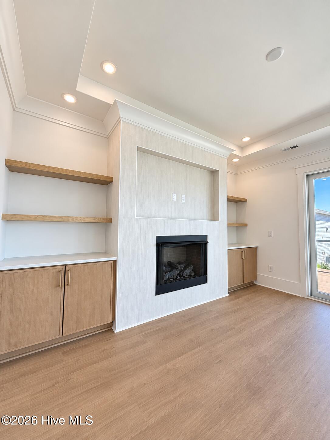 Inviting living space featuring a modern fireplace, custom built-ins and designer accent lighting.