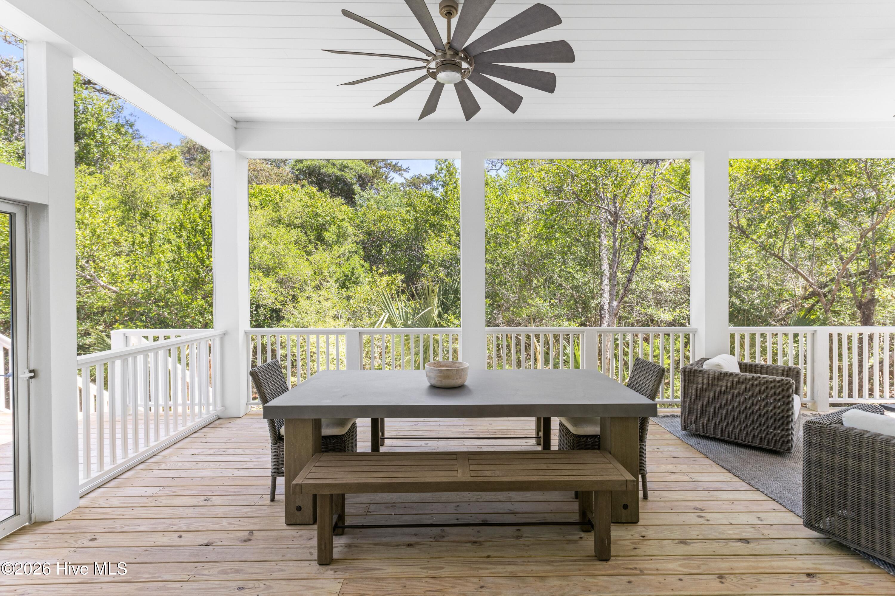 Screened-in porch with dining and seating areas