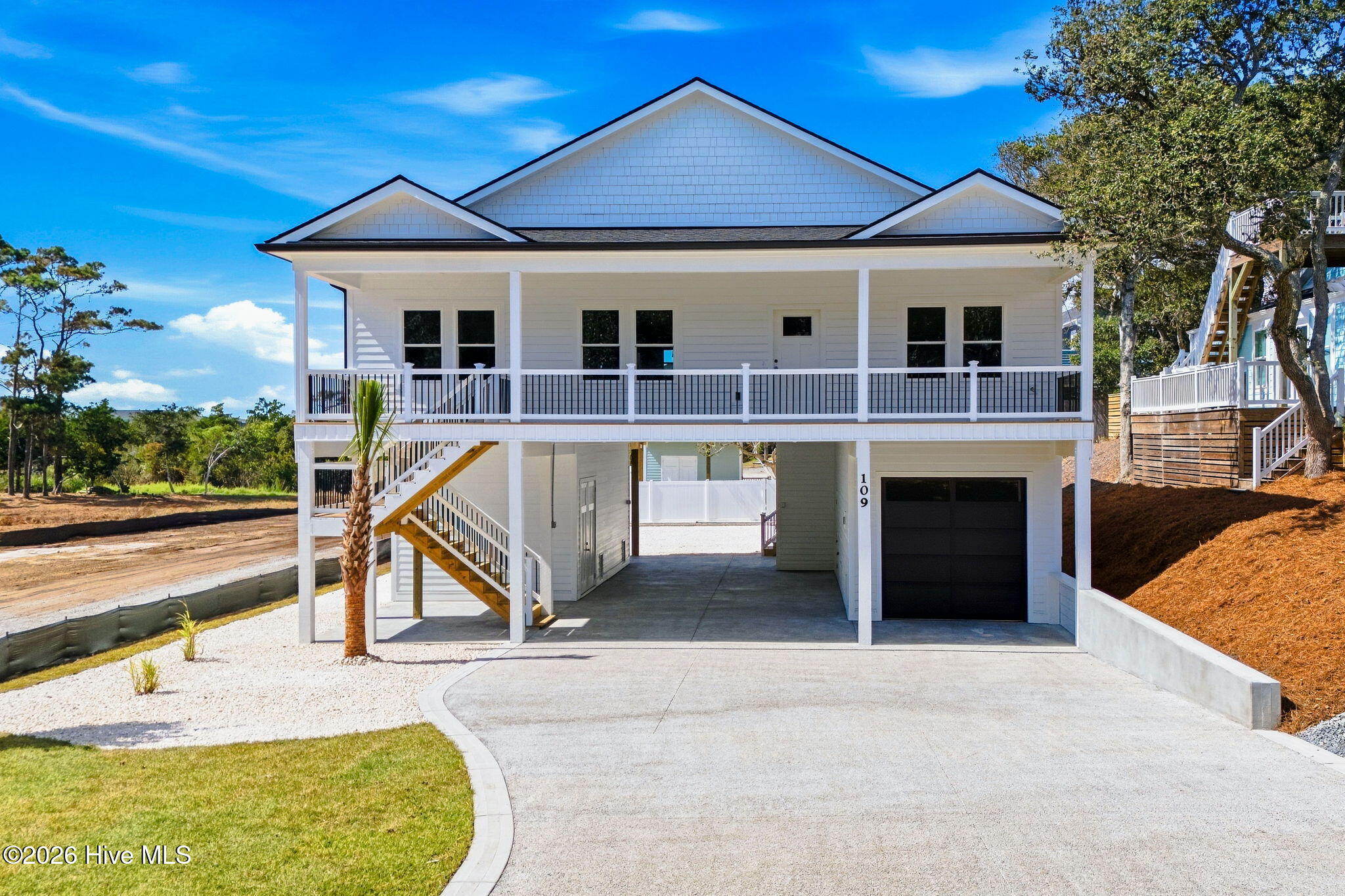 Welcome to your Oak Island retreat. This 3-bedroom, 2 bathroom  home offers effortless coastal living with an elevator, one-car garage, and an open-concept design perfect for gathering. Enter the home into a bright living area anchored by a cozy electric fireplace. The kitchen features quartz countertops, beautiful coastal blue backsplash, white cabinets with lots of storage and a center island ideal for prep and casual dining. Primary bedroom has a shiplap accent wall, trey ceiling, walk in closet with built in storage and en-suite bathroom with dual vanities and walk-in shower. Two additional bedrooms share a hall bath.  Step onto the back porch to enjoy peaceful Davis Canal views and direct access to a shared kayak launch--ideal for morning paddles and sunset adventures. A rare blend of comfort, convenience, and coastal charm. This piling home offers plenty of storage for all your beach with an outdoor shower for convenience. Make your appointment today.