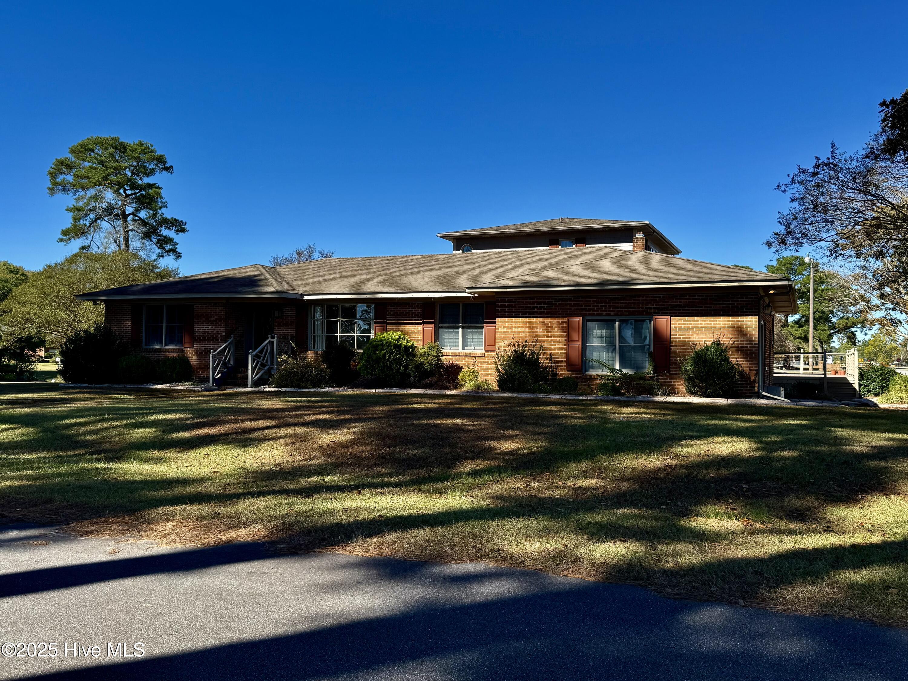 Welcome to a stunning entertainer's paradise! This beautiful 4-bedroom, 3.5-bathroom brick ranch is perfectly positioned on a desirable corner lot overlooking the scenic Roanoke Country Club golf course. At the heart of the home is a chef's dream kitchen, equipped with all stainless-steel appliances, gleaming granite countertops, and expansive room for culinary creativity. For added convenience, the property comes complete with a top-of-the-line LG washer and dryer set, ready for your laundry needs. The kitchen flows into a charming breakfast dining area, where a propane gas log fireplace with a classic mantle creates a cozy atmosphere for casual meals. For more formal gatherings, an elegant dining room features distinguished chair railing and an arched doorway leading into the formal living room, complete with custom carpet and an electric fireplace. The main floor offers three comfortable bedrooms. Two bedrooms share a well-appointed hallway guest bathroom, and there is also a convenient half bathroom specifically for guests. The third bedroom features a private ensuite with a stand-up shower, providing ideal accommodations for family or visitors. A true highlight is the incredible bonus room, ready for any occasion. This space is equipped with a traditional NY-style bar, an electric fireplace, a TV, and a large open area perfect for hosting numerous guests or creating your ultimate recreation space. Ascend to the private upstairs master suite, a secluded retreat featuring custom carpet, elegant drapery, and custom wallpaper. This spacious bedroom includes a large walk-in closet. The matching custom ensuite bathroom is a luxurious escape, boasting a step-in tiled shower, a large whirlpool tub, and double his-and-hers vanities. This exceptional property includes a large composite wood deck for outdoor relaxation or entertaining. Additional features include an attached garage and a separate detached garage/outbuilding for extra storage or workshop potential.
