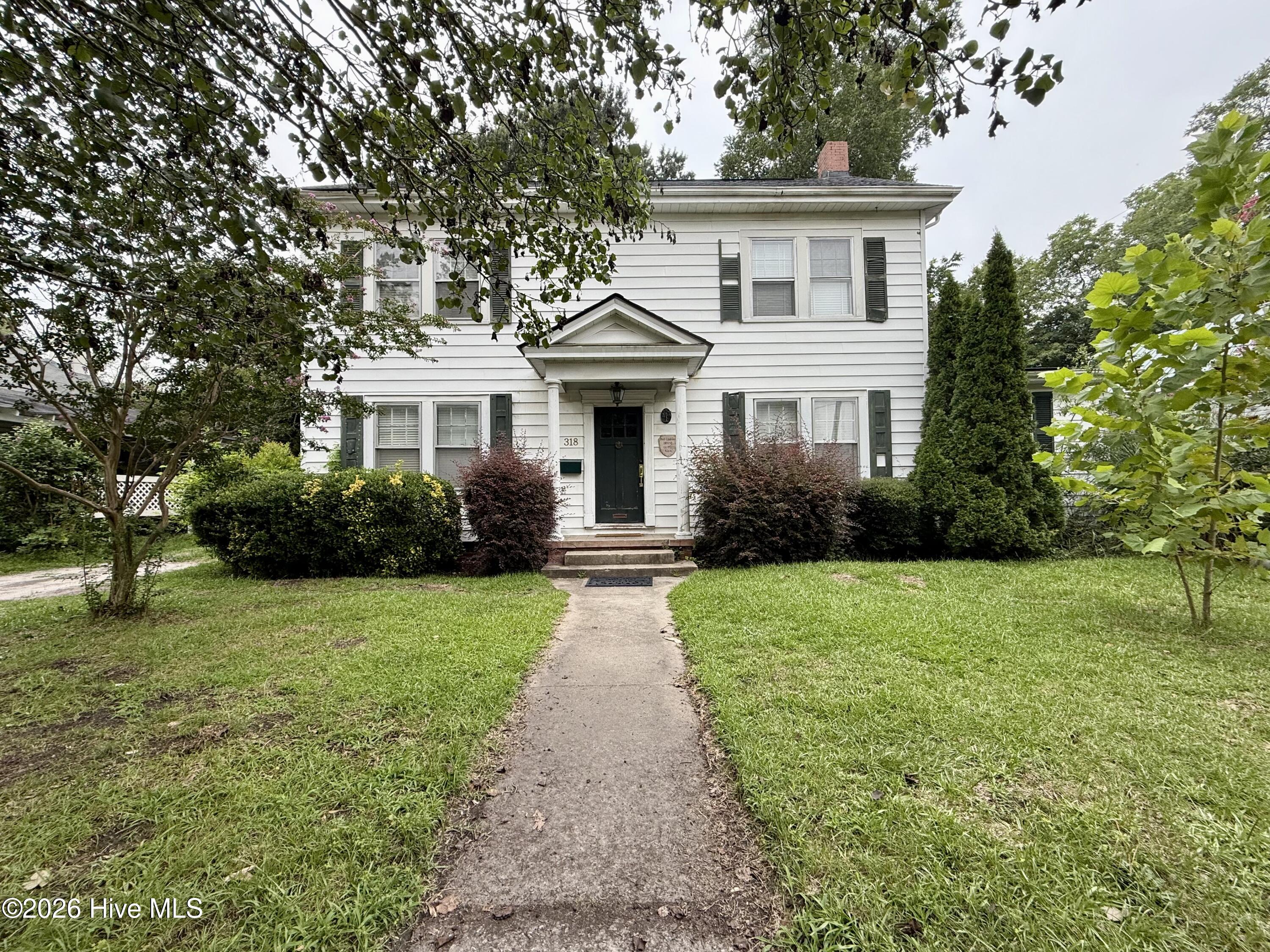 Step back in time and discover the charm of the historic 1927 Peel-Lindsley Colonial Revival home, conveniently located just a few blocks from downtown Williamston. This classic residence showcases an abundance of original character, including hardwood floors, hardware, moldings, fixtures, and architectural details. The roof was replaced in 2025, providing an important recent update.A welcoming foyer is highlighted by a beautiful grand staircase that captures timeless Southern elegance. The living room features a fireplace that is currently closed off, offering the potential to become a beautiful focal point. The updated kitchen features a custom porcelain sink, generous workspace, and a walk-in pantry. Kitchen appliances are not currently functioning and will need to be supplied by the buyer. The adjoining dining room offers custom built-in corner cabinets that add both charm and functionality.The main-level bedroom features tongue-and-groove pine walls, built-in shelving, and a spacious walk-in closet. A full bathroom with a tiled tub and shower combination is also located downstairs.Upstairs, you will find three additional bedrooms and a second full bathroom that is in need of repairs. The home currently does not have a functioning HVAC system. Outside, the large backyard offers plenty of room to enjoy, along with a koi pond and detached outbuilding for additional storage.Connected to city water and city sewer, this remarkable property is filled with history, character, and potential. With repairs and a little TLC, this Colonial Revival home could once again become a stunning showplace. Schedule your private tour today!