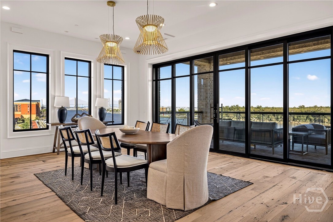 Dining room with balcony and water view. This light-filled dining area is strategically positioned to capture panoramic water views through expansive glass doors. The layout offers direct access to a private balcony, enhancing indoor-outdoor flow and entertaining potential. A serene setting designed for elevated gatherings and natural connection.