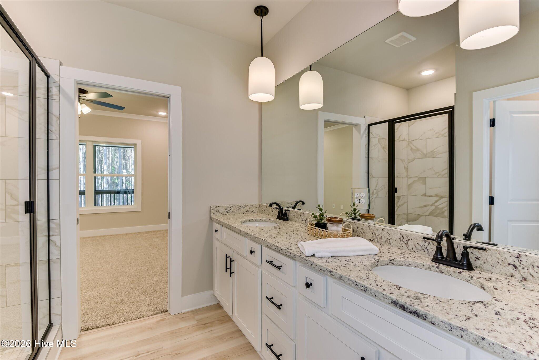 Primary Ensuite with double-sink vanity, tile shower, large walk-in closet