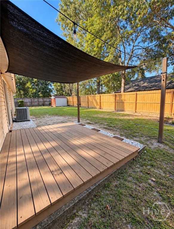 Fenced in backyard with deck and awning.