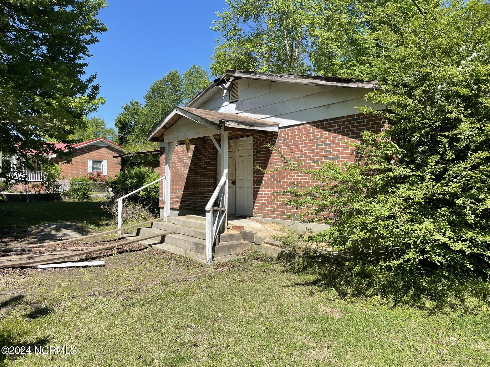 This is your dream come true. No city taxes.  This 1.65 acre double lot has an old church that you can decide to rehab or tear down.  The church lot is large enough to build.  The larger lot has a metal 2 car garage with roll up doors and a side entry.  Add a gravel or concrete floor to make a complete workshop, or move it. Country living where you can raise horses, or other livestock.  The back of the larger lot borders on Collie Swamp Tributay 5.  Build a boat dock for fishing or just kayaking.    Your imagination is the only limitation. No access to old church. Selling As-Is seller not making any repairs
