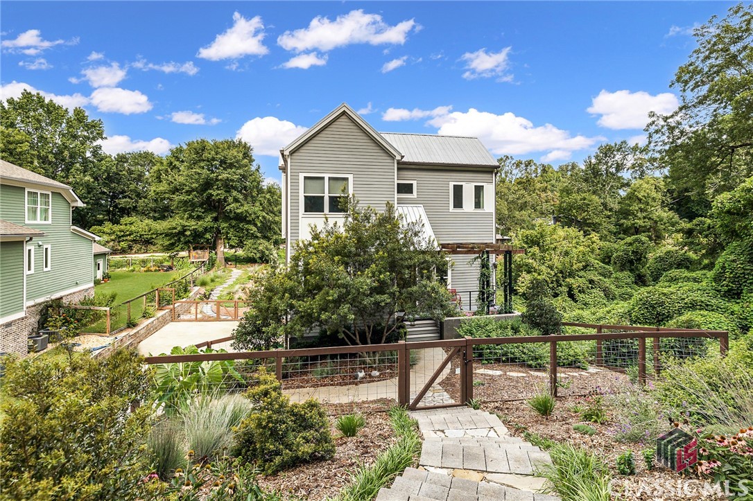 Convenience and location are key with this newly listed contemporary home situated in the highly sought after Boulevard District.  A quick walk to Downtown Athens is made possible by direct access to a path which leads to the Leathers building; home to the local favorite, Pulaski Heights Barbeque and other businesses!   Furthermore, the house is convenient to Buvez, Jittery Joe's Roaster, Boulevard Neighborhood Park, and all that Normaltown/Boulevard have to offer, with new establishments in the making. This home offers an open and bright floor plan, with the dining area, den, and kitchen flowing seamlessly into each other. The streamlined modern kitchen offers quartz countertops, custom cabinetry, a spacious island, beautiful subway tile backsplash, under counter lighting, gas range, built-in microwave oven, and stainless appliances. The den/kitchen opens onto the screened-in porch and deck, creating a perfect space for grilling and relaxing. With an excellent view of the fully fenced, professionally landscaped backyard with fire pit and playground, this will be a highlight for outdoor entertaining. The main floor also features a guest suite (currently being used as an office) with an en suite bathroom.  Upstairs is home to a spacious owners suite with vaulted ceilings, hardwood floors, and amazing natural light.  The owners suite bathroom features a double vanity and spa like shower with frameless glass doors. There are two other carpeted secondary bedrooms upstairs that share the full, hallway bathroom. A laundry closet is conveniently located near the bedrooms.  Downstairs, there is a newly finished workshop/storage room (which could make a great gym space) and a large coat closet.  The two car garage is a convenience rarely found in this neighborhood! All of the following features are new in the last two years.....hardwood maple floors throughout, the carpet in the two secondary bedrooms, all new interior paint, washer/dryer (to convey with the house), many new light fixtures, much of the landscape and some hardscape, and the kids play area with slide. All of the furnishings in this artfully decorated home are negotiable.  This is a turn key property, and is move-in ready for the next owner. Tucked away on a quiet, private street,  and offering incredible access to all that Athens has to offer; this could be the home of your dreams! Come and preview it today before it is too late!