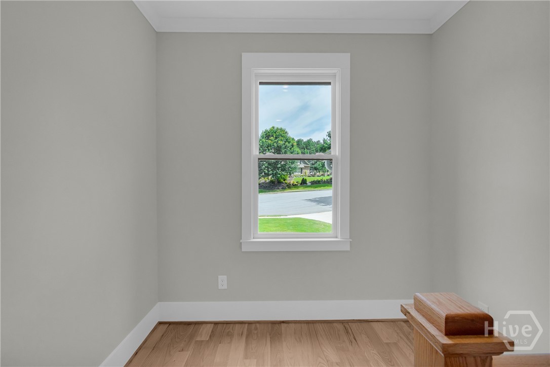 Upper-level hallway featuring wood-finish flooring, white baluster railing with wood newel posts, recessed lighting, and panel doors with dark hardware