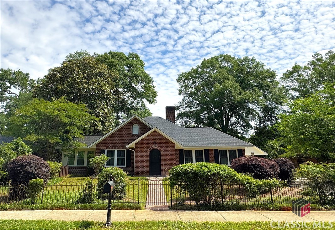 In Heart of Normaltown is where you will find this Pre-WWII brick bungalow.  It has been enlarged and improved and now features 4 bedrooms and 3 1/2 bathrooms with space for everyone.  The front door is followed by a vestibule that opens to the living room with period sconces above the tile and brick fireplace.  There is a sunroom or 4th bedroom off of the living room with a generous dining room just around the corner.  The chef’s kitchen is there with specialty lighting, Wolf stove, custom cabinets, and solid surface tops.  Beyond the kitchen is the all-new great room with vaulted ceiling, access to the covered deck and the grilling deck.  The addition also includes one bedroom and a bath.  The well-lit owner’s suite is at the back of the home with a private bathroom featuring twin pedestal sinks, soaking tub and separate shower. There is another bedroom up front with a private entrance and sunroom.  There is plenty of room for attic expansion and the stairs are already in!  Don't miss the practical carport and huge driveway/play area.  This one is only minutes to The Farmer's Market, Normaltown, Downtown, The Health Sciences Campus, and UGA.