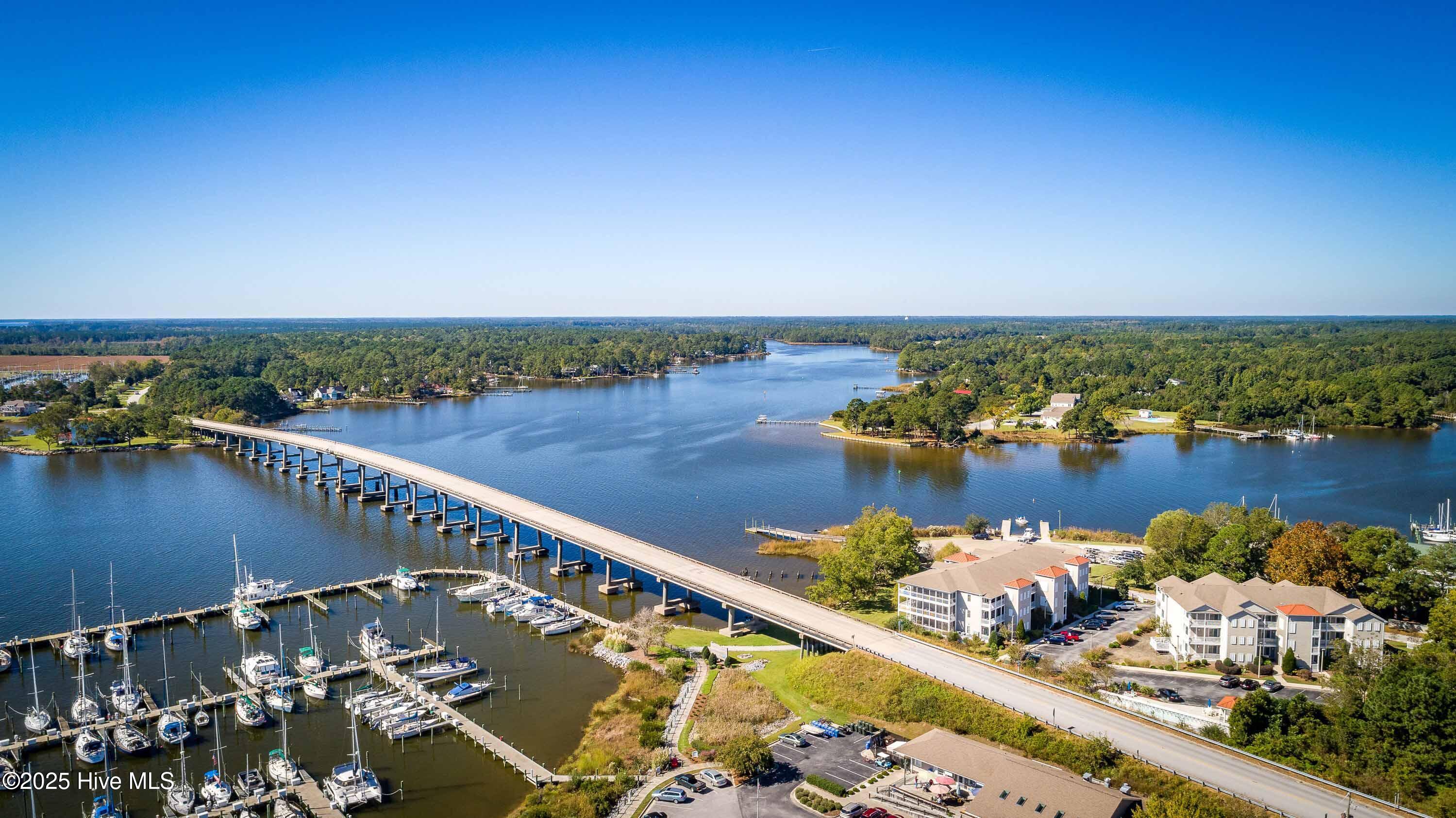 300 Midyette Street # B2 Oriental, North Carolina Enjoy carefree coastal living in this beautifully appointed 2-bedroom, 2-bath, condominium with elevator access in the heart of Oriental. The open-concept living and dining area features heart pine floors, plantation shutters, a cozy gas log fireplace, and flows to a private balcony with sweeping panoramic water views—perfect for watching sunrises, passing boats, and evening breezes. The kitchen offers solid surface counters, pantry, and a Jenn-Air stainless refrigerator, while updated baths showcase quartz counters. The primary suite includes an en suite bath and walk-in closet, with a guest bedroom and full bath providing comfort for visitors.
Just steps away, the village of Oriental offers seafood and casual dining restaurants, a coffee shop, bakery, wine bar, brewery, and live musical entertainment—all in a peaceful harbor setting known for its sailing heritage. Ideal for year-round living, a weekend retreat, or an investment property.