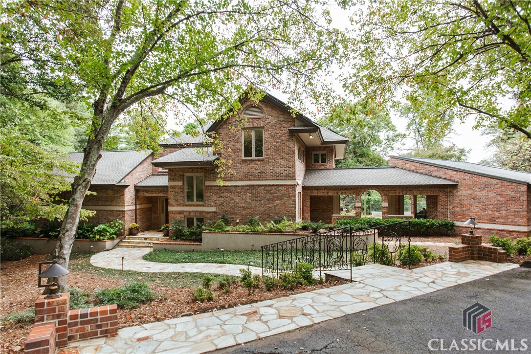 Spectacular all-brick custom home, nestled serenely on a wooded lot within the prestigious Renfrew neighborhood along the Timothy Road corridor.As you enter the house, a magnificent two-story entry foyer unfolds before you, setting the stage for the opulence, elegance, and sophistication that define this remarkable estate. Rich hardwood flooring, soaring 10-foot ceilings, and custom decorative light fixtures enhance every corner of this incredible residence.The main level has been meticulously crafted to offer a haven of comfort and boundless versatility.Enter the dining room, where grand archways beckon you into a space that effortlessly flows into adjoining rooms. Here, you will discover high-quality custom-built cabinets adorned with marble countertops, creating a dining sanctuary that is nothing short of regal. The beautiful dining room seamlessly extends into an eclectic living room, graced with skylights that usher in the warmth of the sun, a majestic masonry fireplace, a convenient wet bar, custom shutters, and double French doors that open onto an expansive flagstone terrace.The state-of-the-art kitchen is a masterpiece of modern culinary design, featuring custom high-end cabinets harmoniously paired with marble countertops, a stunning 5x10 ft. quartzite center island, Zellige weathered white backsplash, and the pinnacle of innovation – HESTAN appliances. These culinary marvels include a refrigerator, freezer, two wall ovens with dual convection fans and a warming drawer, as well as a HESTAN five-burner and grill combo gas cooktop crowned by a matching 48” Pro Canopy Venthood. For added convenience, two Bosch dishwashers stand ready to make cleanup a breeze. An open breakfast room, bathed in natural light, features Pella sliding doors and windows with custom shutters, inviting you to enjoy the rear terrace overlooking a full-sized, private tennis court. Adjacent to the primary kitchen lies a separate, charming entertaining kitchen, equipped with perfectly matched cabinetry, vent hood equipment, and its own mini-split A/C unit.Accessed from the main hallway, a generous laundry room awaits, thoughtfully finished with a sink, cabinets, extra pantry space, and a convenient breezeway leading to the three-car carport with additional outside storage.The main level is perfected by the owner's suite, a sanctuary of luxury boasting deep tray ceilings, abundant closet space furnished with custom-built closet systems, and a breathtaking bathroom. This oasis features a extensive walk-in shower room, a Brain Ultra Soaking Tub, and meticulously crafted walnut vanities. Adjacent, a private executive paneled library/office awaits, offering a space for quiet contemplation. A coat closet and a half bathroom complete this level.Ascend to the upper level, where you will discover two spacious bedrooms with custom built-ins, two tiled bathrooms, and an inviting, generously lit sitting/flex area adorned with skylights and additional closets. The attic provides extensive additional storage space for your convenience.The terrace level mirrors the high-quality finishes found on the main floor, boasting oak engineered hardwoods. Here, you will find an additional bedroom with an ensuite full bath with custom walnut vanity courtesy of Normaltown Woodworks, a media/gym room that opens onto a private flagstone-paved patio, perfect for tranquil moments of reflection. This exceptional property boasts red oak hardwood flooring throughout, Pella doors and windows, water purification systems, an integrated whole-house Cummins 20 KW Generator, new roof, and Solar Panels paired with a Fortress Battery. Truly a one-of-a-kind property in a convenient location, offering proximity to schools, restaurants, shopping, medical centers, Five Points, and The University of Georgia.