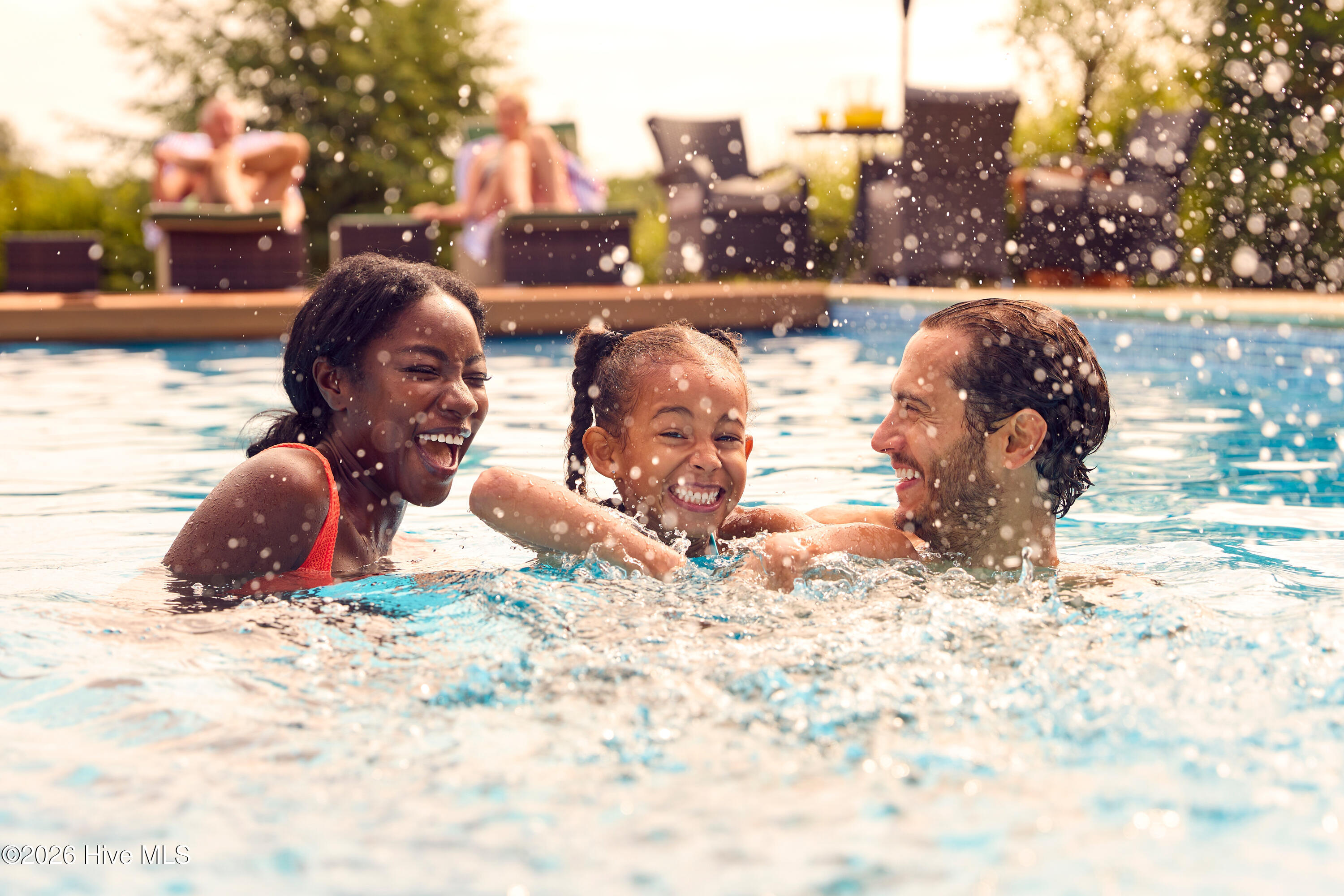 Mixed Race Family Splashing in Pool
