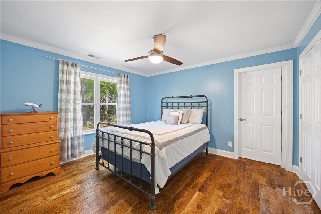 Comfortable bedroom with hardwood floors, soft nat