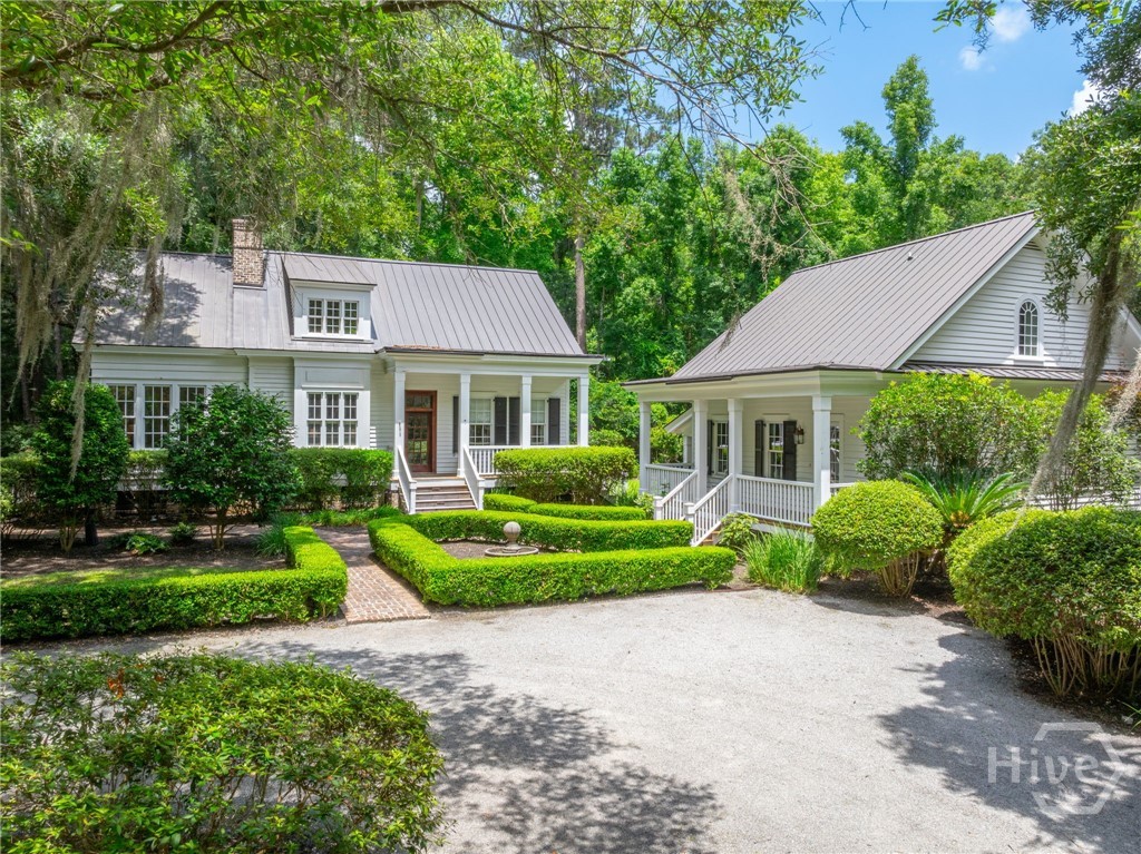 Discover the epitome of Southern charm in this immaculate Lowcountry cottage, nestled beneath centuries-old oak trees within the exclusive Ford Field and River Club, just 20 minutes south of Savannah, Georgia. This serene retreat features a 3-bedroom main house with the master suite conveniently located on the main floor, offering luxurious living with high ceilings, hardwood floors, and a gourmet kitchen. The living room and dining room boast floor-to-ceiling windows that flood the space with natural light. The property also includes a detached 2-car garage with a charming guest suite above, complete with a full bathroom and kitchenette, perfect for visitors or a private office. Enjoy the tranquil surroundings and exclusive amenities of Ford Field and River Club, including a private golf course, equestrian center, marina, and clubhouse dining, all while being enveloped by the natural beauty of the Lowcountry.