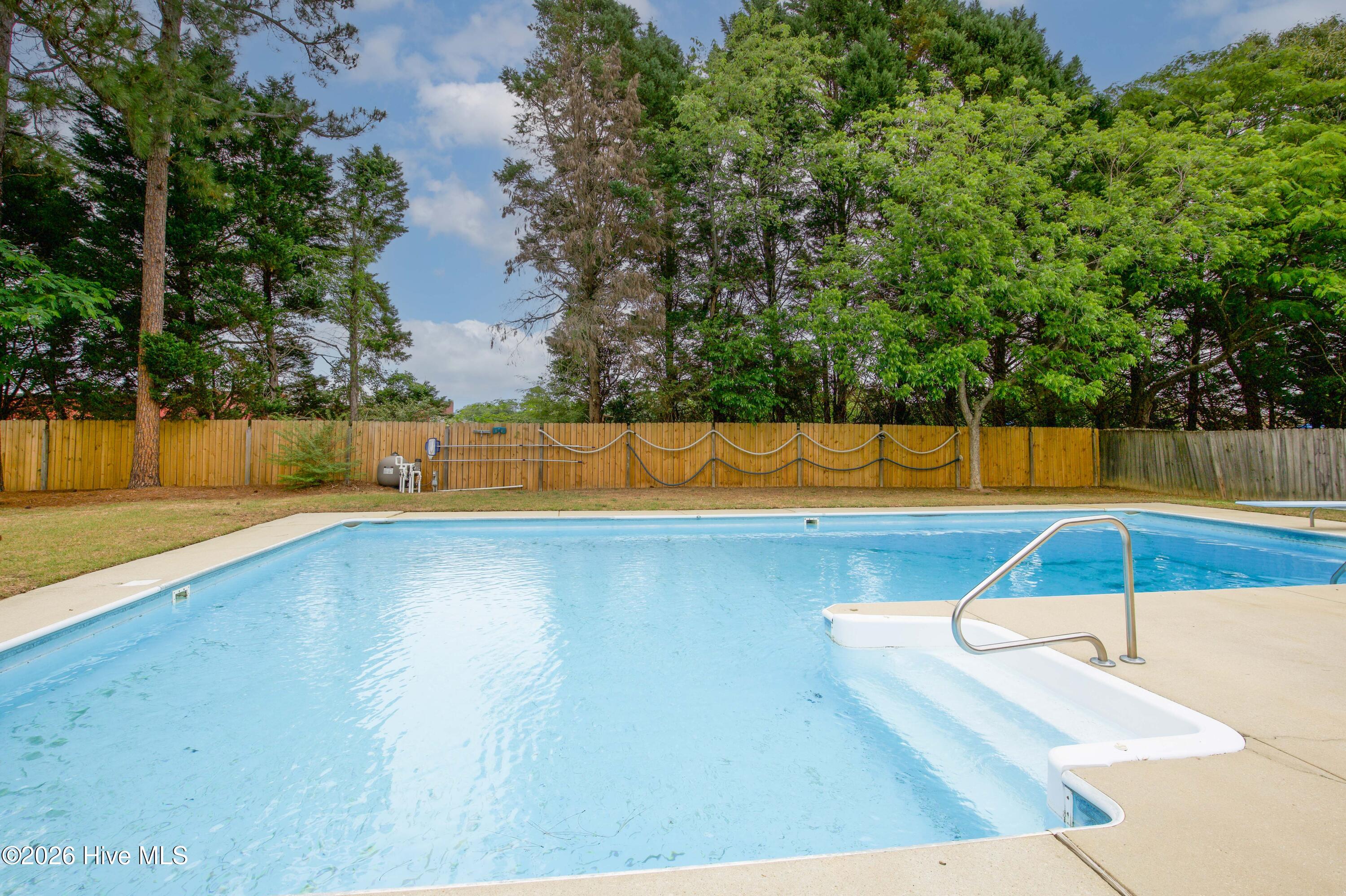 Private backyard retreat featuring a large in-ground swimming pool surrounded by mature landscaping and fenced privacy. This outdoor setup provides plenty of room for recreation, entertaining, and relaxing while maintaining a peaceful atmosphere difficult to find in many Fayetteville neighborhoods. Buyers relocating during PCS season continue to prioritize homes with outdoor lifestyle amenities and flexible entertaining spaces.