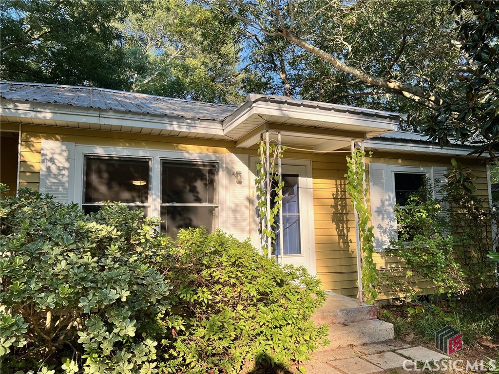 Historic 1950s 3/2 cottage, with a highly desired Boulevard address, and a rare, park-like backyard, within several blocks of UGA’s historic 58 acre Health Science Campus, over 30 acre Bishop Park ( with recreational fields, tennis courts, walking trails, swimming pool, and host to a seasonal local Farmer’s Artist’s Market ) , Piedmont hospital, Chase Street Elementary, and Normaltown’s array of restaurants, coffee shop, pubs, live music, 2 grocery stores, fresh juice bar, and much more. This is a wonderfully central intown location, with an abundance of walk/bike destinations. This small, but efficiently laid out, cottage sits on a deep .33 acre lot, with a fenced, lush back yard. There’s a rear deck, just outside the kitchen back door, overlooking courtyard type space, and multiple paths that disappear into this forested intown oasis, with oak, pecan, walnut, magnolia, redbuds, buckeye, mahonia, dog hobble, beauty berry, kerria, azaleas, gardenia, sweet shrub, forsythia, a stand of bamboo screens the very rear of lot, and there’s a variety of perennials that delight throughput the year. This green sanctuary seems to entice a wide variety of birds, who lend their symphonic voices and presence to this space. Returning to the cottage, the common area runs through the center of the house, with 2 bedrooms and a common bath off a small hall to right of communal living area; to the left of the common area is an owner’s suite. Most of the flooring throughout the house is oak, both baths have recently seen updates, the kitchen is older, yet with it’s own colorful charm, and a new metal roof was added in 2022.  Should one need additional living space, the lot size can certainly accommodate an addition, and/or a secondary structure: a guest cottage, studio space , office, workshop, etc.  There’s 2 off street parking spaces in front of house. The front of cottage is somewhat privately veiled by a large Magnolia, azaleas, gardenia, and other evergreen plants. The neighborhood is generally considered one of the most arts-centric in Athens. This may be the intown sanctuary you’re looking for…