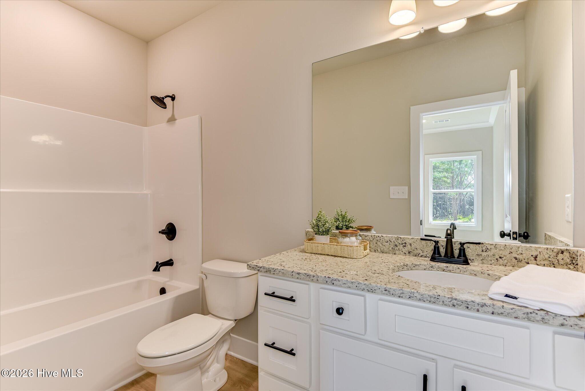 Primary Ensuite with granite countertop and tub/shower combo.