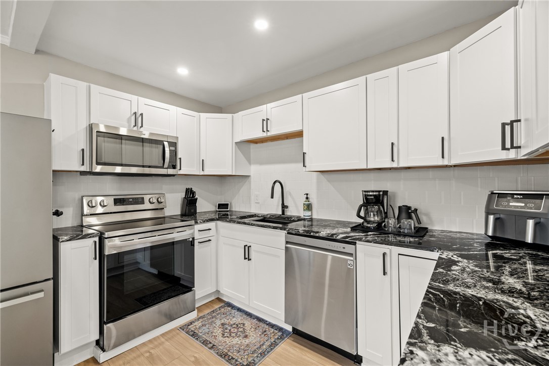 Updated kitchen with stainless steel appliances and granite counters