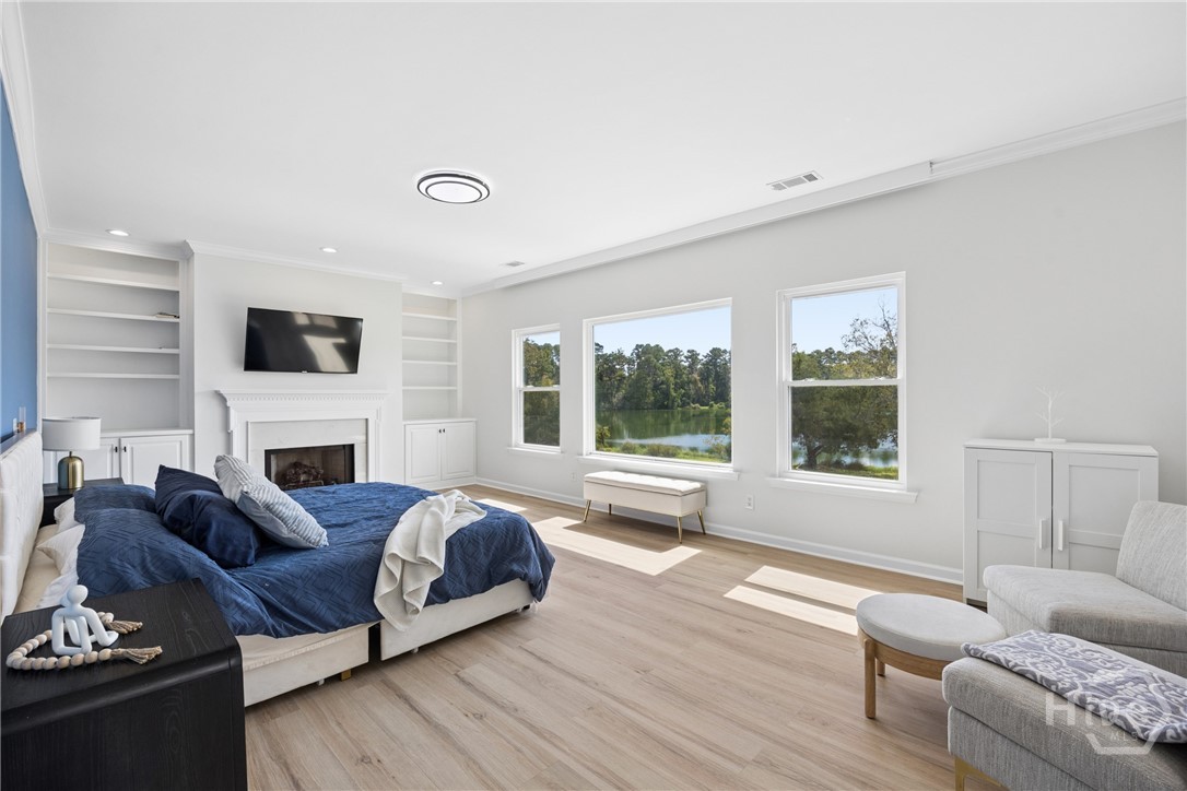 Built-in-bookshelves accompanied by a wood-burning fireplace, situated beside the best view on the property at the center of it all -- this Master Bedroom will have you smiling as you wake up and go to bed. Look at that space!