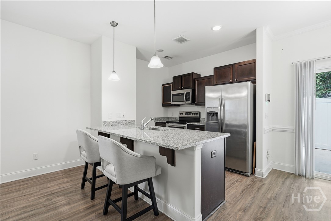 Kitchen features granite countertops and tall cabinetry.
