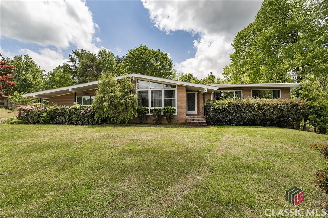 Here it is! A charming mid-century style home in Cornelia that is completely move-in ready! This gem is nestled in the highly sought-after Tower Mountain neighborhood in Habersham and boasts numerous desirable features. You’ll love the new energy-efficient windows and gorgeous hardwood floors throughout. The kitchen has been beautifully remodeled with an open-concept layout and a large eat-in island that flows seamlessly into the separate dining area. The living room is filled with natural light, making it a perfect spot to hang out and relax. And let’s not forget about the spacious backyard, which offers endless possibilities for outdoor enjoyment and relaxation, with its leveled terrain and peaceful wooded backdrop.