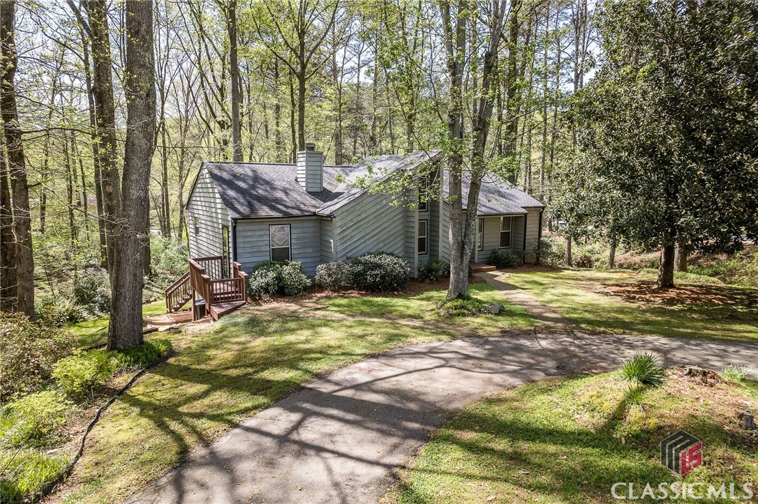Natural beauty surrounds this Cedar Contemporary in Athens' West Side neighborhood, Holly Hills. Sited on over half an acre corner lot with babbling brook, this property is full of mature landscaping including Azaleas, Magnolias, Tulip Poplars, and more. Fresh interior paint throughout the home in 2023! The Greatroom features vaulted ceiling, oak flooring, and a flagstone fireplace. Spacious breakfast room has newer sliding glass door that provides access to the screened porch with freshly stained decking and beautiful views of the backyard and brook. Plenty of cabinet and counter space in the bright kitchen with stainless steel appliances. Off the kitchen is a home office w/ its own entrance, potential fourth bedroom, or even a mudroom/ laundry room with a little remodeling. Owner's suite on the main level has vaulted ceiling, clerestory window, two closets, and an ensuite bath with tiled shower. Two additional bedrooms share a hall bathroom with shower/tub combo. Laundry closet is centrally located to all bedrooms. Finished basement features a den and spare room for storage. Fenced backyard is peaceful and private. Additional updates include double pane windows, new roof (2017), new HVAC (2019), fresh interior paint (2023), as well as new vapor barrier and interior French drain system with sump pump in crawl space (2023). Don't miss this wonderful home priced just under 300K!