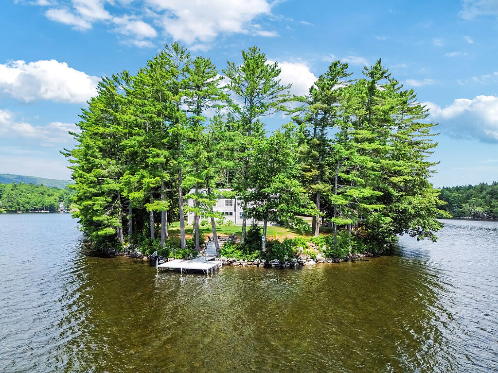 LONG POND This exceptional family compound located on its own private 2.27AC peninsula with 1,300' of lakefront has room for everyone with a 4BR/4BA year-round home, 1BR/1BA year-round guest house and large carriage house with year-round living space and full bath!  The gorgeous contemporary home was completely rebuilt from the foundation up in a grandfathered footprint just steps to the lake with quality materials and craftsmanship and designed to take advantage of the long lake views and all day sunshine.  A large Great Room is the focal point of the home, with 27 foot vaulted ceilings and a natural stone custom fireplace which opens to the lovely lakeside screen porch, dining room & kitchen. The impeccable kitchen includes an oversized island perfect for entertaining, double ovens, quartz countertops, custom cabinets, two dishwashers, large pantry and Miele gas stove. The first floor primary suite is its own oasis with lake views, two large walk-in closets and a spacious bathroom with walk-in shower, while the laundry & powder room complete the first level. Above is a cozy den, loft with office, a second ensuite bedroom with private full bath, second office (or 5th bedroom), two guest bedrooms & full bath. Home has both heat and AC supplied by an efficient geothermal system. The guest house was completely renovated top to bottom with all new flooring, lighting, kitchen, bath & more, offers one floor living, large lakeside deck, lakeside garage for your boats & water toys, 2 car garage and laundry. The large carriage house has two oversized bays perfect for your RV or boat, 3 additional bays, workshop, & full bath on ground level, and above is a year-round living room with 2 heat pumps. The property benefits from two dock systems, large lakeside patio with fire pit, new 30kW Kohler whole property generator, all new landscaping including perennials, shrubs & lawn all on one of Maine's best lakes! This is the lakeside legacy property you have been searching for!