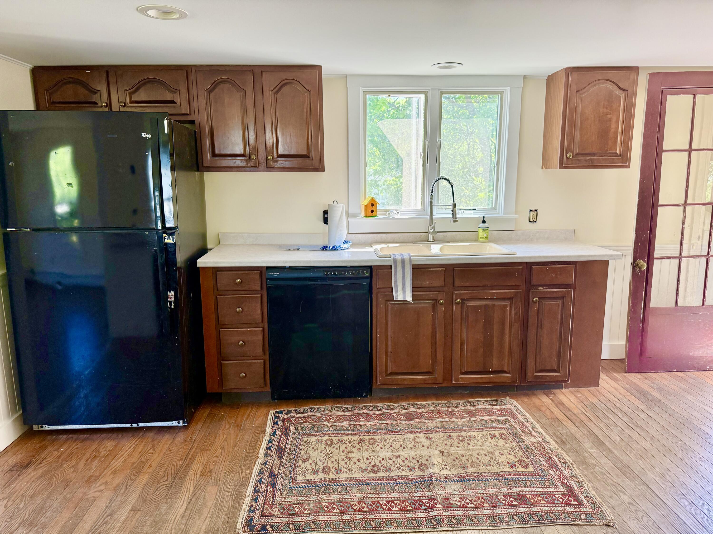 Kitchen has wood floors and warm off white walls.
