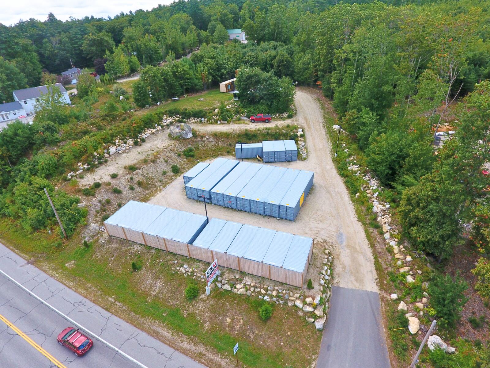 Unlock the potential of a thriving income-producing property in the Lakes Region's most visible commercial corridors. Located on highly traveled Route 302 in the heart of Naples, this exceptional 1.58-acre commercial property features an established self-storage business with strong long-term investment appeal and 100% occupancy.  The facility consists of 25 shipping containers configured into 35 individual storage units, providing an efficient, low-maintenance operation with proven demand and attractive revenue potential. Thoughtfully designed for operational efficiency and investment opportunity.  A standout feature is the professionally converted shipping container office, complete with a kitchenette, spare room, heat pump, laundry, and full bathroom, creating a comfortable and functional on-site management space. The property is further enhanced by a new well and septic system, adding value and reducing future infrastructure concerns.  With outstanding Route 302 frontage, excellent visibility, and potential future development, this is a rare opportunity to acquire a versatile commercial asset in a growing destination market.  Tractor, golf cart, RV, and enclosed utility trailer are not included in sale but are negotiable.